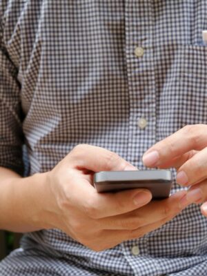 Close-up of a man using a smartphone, focusing on hands and modern technology.